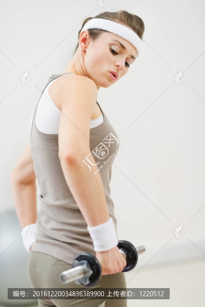 健身女子舉起啞鈴在健身房