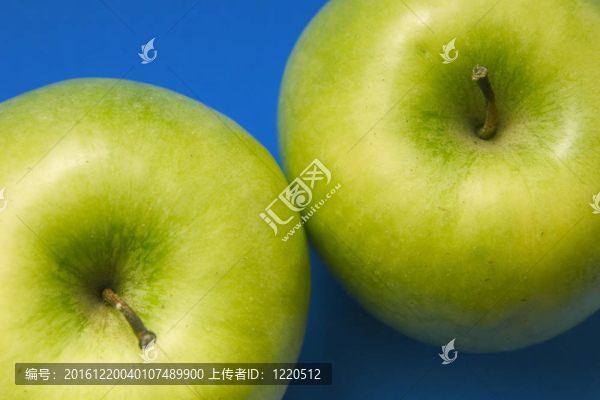 兩個(gè)美味的蘋果綠色在藍(lán)色的背景