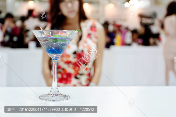 一杯藍色雞尾酒（OLE）和背景的性感女孩