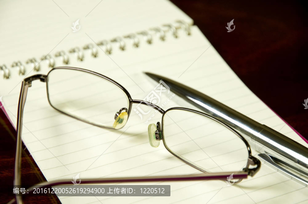 在筆記本上閱讀眼鏡和鋼筆