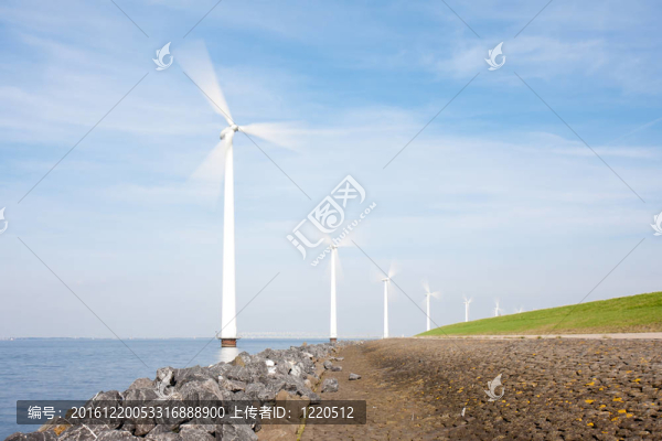 旋轉(zhuǎn)的風(fēng)力發(fā)電機(jī)站在長(zhǎng)海邊拍照