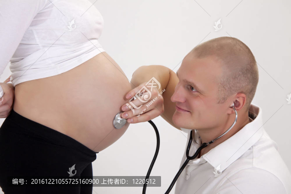 懷孕.醫(yī)生用聽診器聽病人。