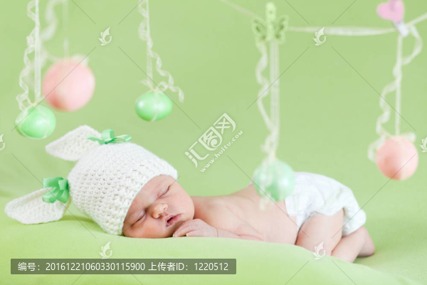 可愛的嬰兒穿著復(fù)活節(jié)兔子帽與雞蛋