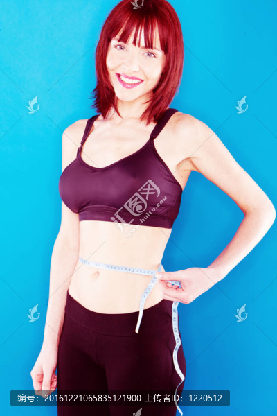 女人穿著運(yùn)動(dòng)服測(cè)量她的腰