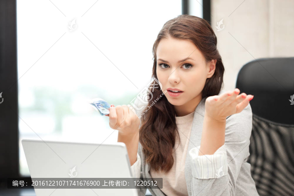 不幸的女人用電腦和歐元現(xiàn)金