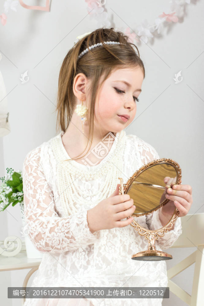 一個(gè)漂亮的小女孩望著小鏡子
