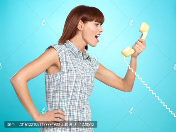 迷人的年輕女子在電話上尖叫