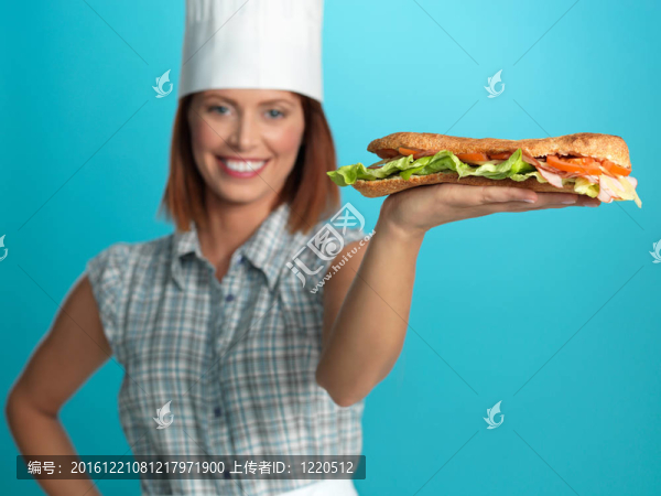 手上拿著一個(gè)大sadwich廚師