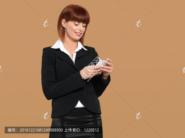 有吸引力的；年輕的女商人發(fā)短信的手機
