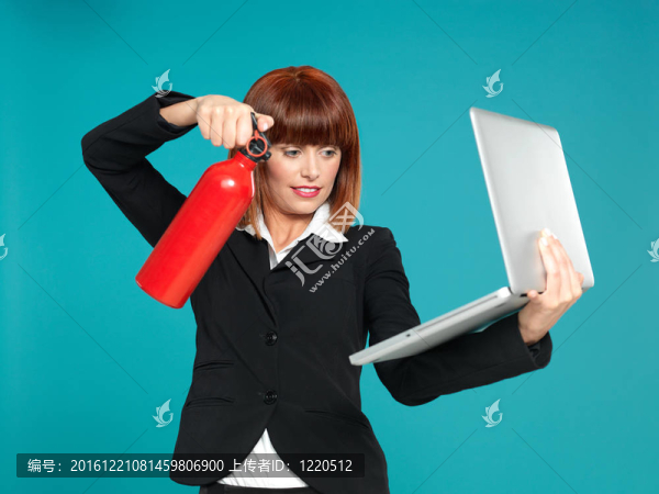 漂亮的女商人；使用滅火器對(duì)筆記本電腦
