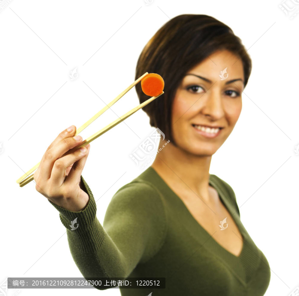 年輕快樂的女人拿筷子拿胡蘿卜片