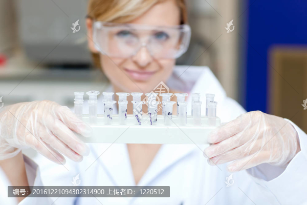 一位面帶微笑的女科學家在實驗室里舉著不同的樣本