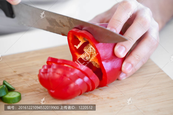 一個年輕白人男子在家里廚房切黃瓜