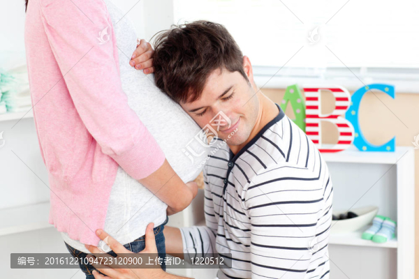 一個(gè)可愛的男人頭上的女人的腹部在家里
