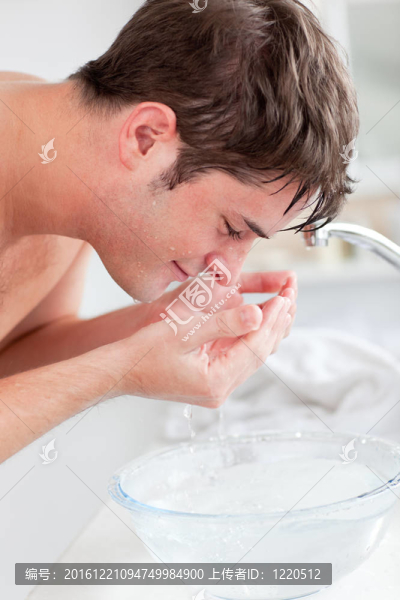 積極白人男子噴灑在他的臉上的水后，在家里的浴室剃須