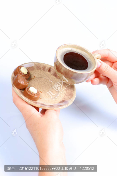 果仁巧克力；杯；黑咖啡和女性手上白色