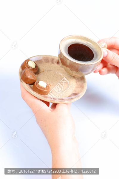 果仁巧克力；杯；黑咖啡和女性手上白色