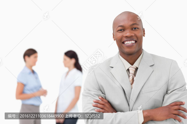 微笑的推銷(xiāo)員，雙臂交叉，背后有伙伴