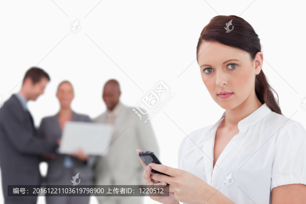 隨著手機和同事在她身后的女商人