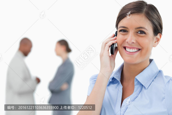 帶著手機和同事在她身后的女商人