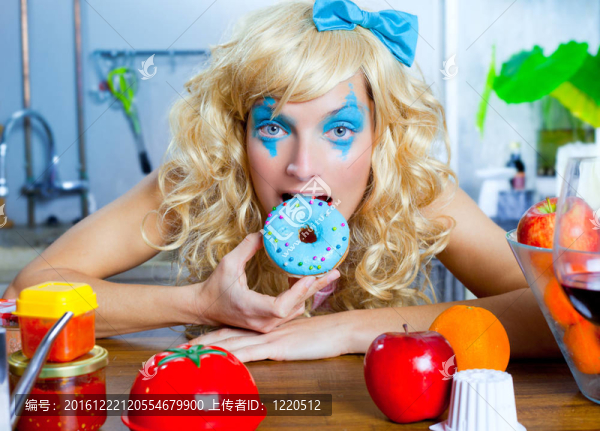 金發(fā)碧眼的有趣的女孩在廚房吃藍小姐