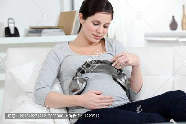 孕婦把耳機放在肚子上