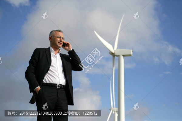 男子在移動電話旁邊的風力渦輪機