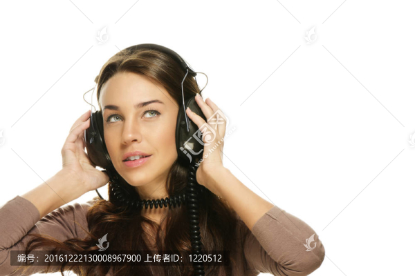 美麗的女人聽著音樂看著白色的背景