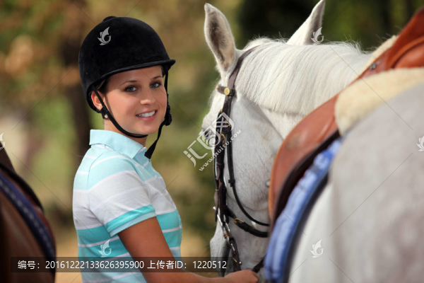 年輕女子照顧她的馬