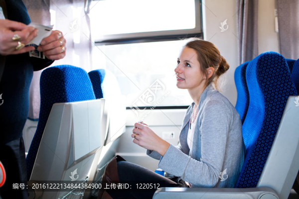 年輕女子乘火車旅行；火車票由火車售票員檢查