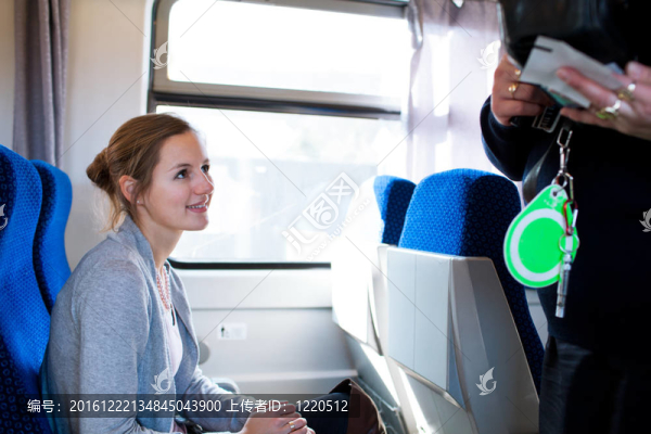 年輕女子乘火車旅行；火車票由火車售票員檢查