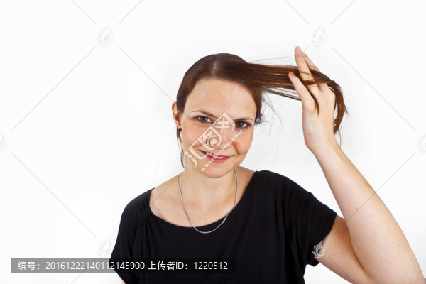 迷人的年輕女子微笑著玩弄她的頭發(fā)