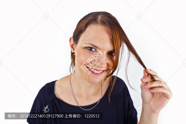 迷人的年輕女子微笑著玩弄她的頭發(fā)