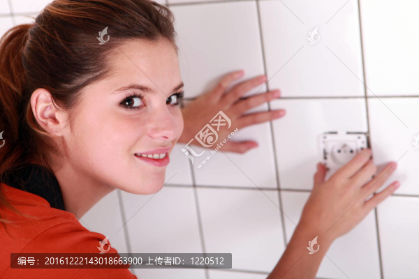 在浴室里安裝插座的女人