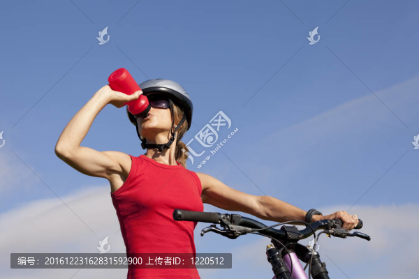 女人在她的自行車喝水