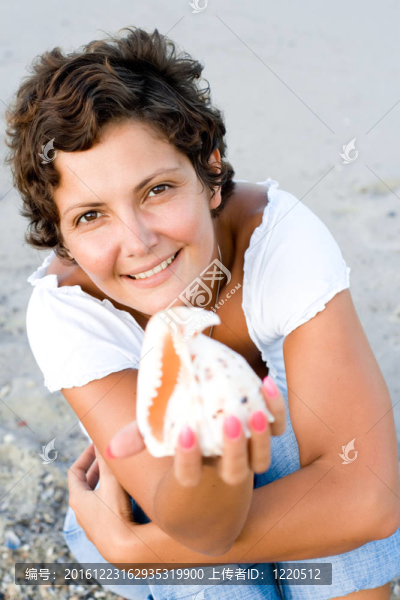 捧著小船在海岸的女人