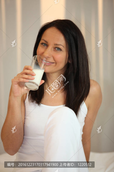 白衣女子喝一杯牛奶