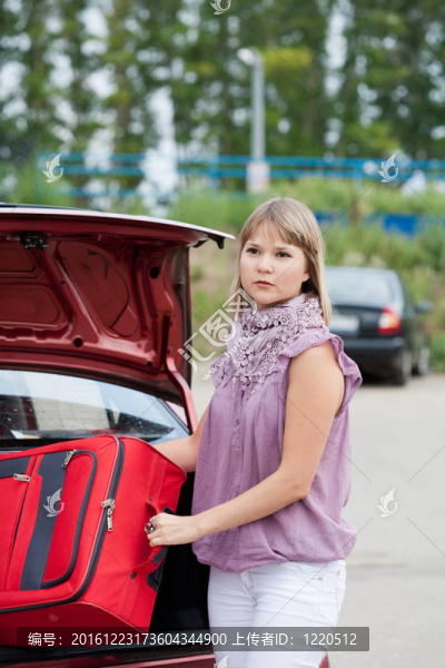 金發(fā)女人把她的行李裝進汽車