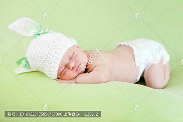 搞笑睡新生兒。兔子帽女孩的頭。