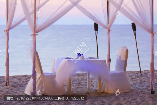 海灘上浪漫晚餐的好去處。長(zhǎng)曝光鏡頭。專注于餐具；淺景深。