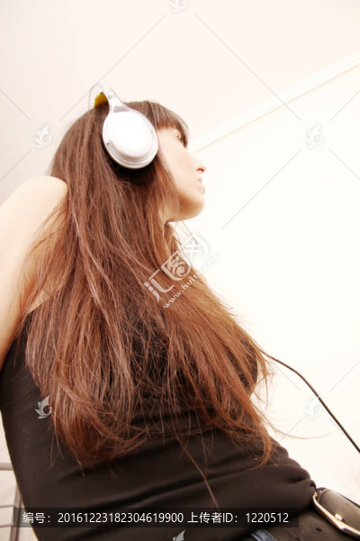 一個年輕的女人帶著耳機(jī)聽音樂。