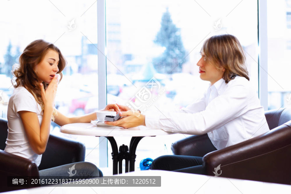 在餐廳里戴著訂婚戒指的年輕夫婦
