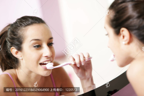 年輕女子在浴室清洗牙齒