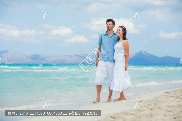 快樂(lè)的年輕情侶在熱帶海灘散步