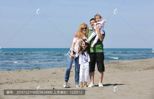 快樂的年輕家庭在海灘上玩得開心