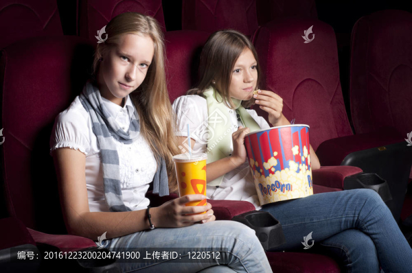 兩個(gè)漂亮的女孩在電影院看電影