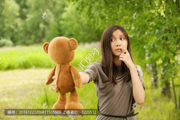 抱泰迪熊的年輕女子
