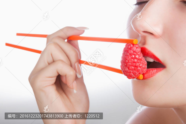 女孩用筷子和覆盆子