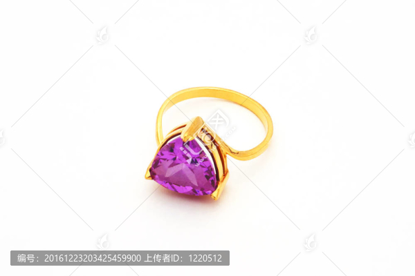 明亮的金戒指，石頭躺在白色的背景上