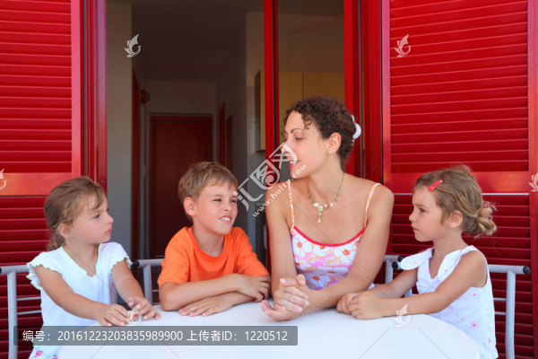三個孩子和母親坐在陽臺的圓桌旁斗